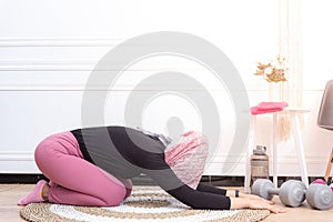 Healthy asian muslim woman stretching while doing exercise at home