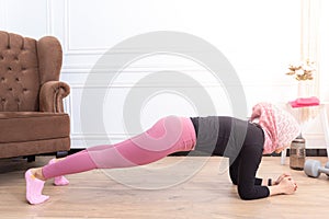 Healthy asian muslim woman stretching while doing exercise at home