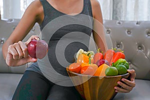 The healthy Asian pregnant young woman holds the apple with many kinds of fruit and vegetable