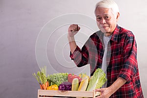 Healthy Asian senior man with crate full of fruits and vegetables