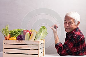 Healthy Asian senior man with crate full of fruits and vegetables