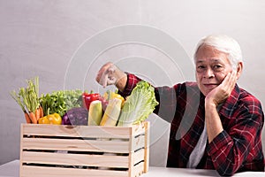 Healthy Asian senior man with crate full of fruits and vegetables