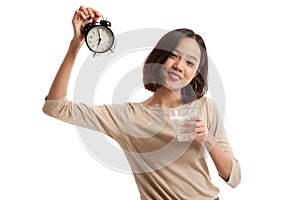 Healthy Asian woman drinking glass of milk hold clock