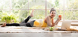 Healthy Asian woman lying on the floor eating salad looking relaxed and comfortable