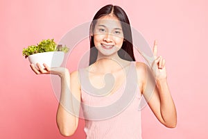 Healthy Asian woman show victory sign with salad