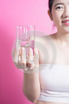 Healthy asian young beautiful woman drinking water, beauty face natural makeup, isolated over pink background.