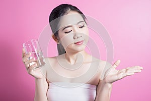 Healthy asian young beautiful woman drinking water, beauty face natural makeup, isolated over pink background.