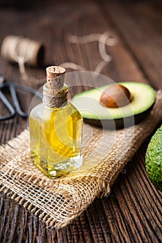 Healthy avocado oil in a glass bottle, decorated with sliced avocado