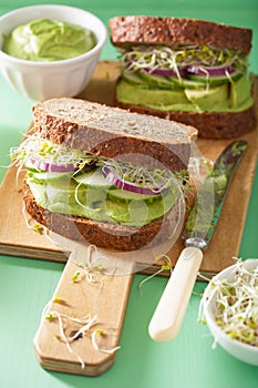 Healthy avocado sandwich with cucumber alfalfa sprouts onion