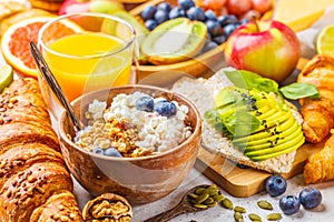 Healthy balanced breakfast on a white background. Muesli, juice, croissants, cheese, biscuits and fruit breakfast backgound