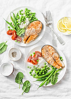 Healthy balanced mediterranean diet lunch - baked salmon, rice, green peas and green beans on a light background, top view.