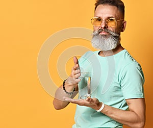 Healthy bearded man demonstrating purified water in glass portrait