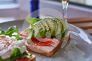 Healthy and beautiful breakfast of boiled eggs benedict, fresh avocado, tomatoes and figs, watermelon on toast with coffee