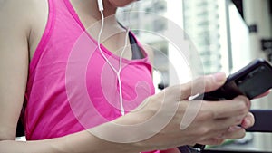 Healthy beautiful young Asian Athlete woman using smartphone for listen to music while running in urban city.