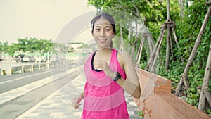 Healthy beautiful young Asian runner woman in sports clothing running and jogging on street in urban city park. Lifestyle fit and