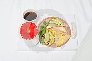 Healthy bed breakfast with fresh avocado, cheese, bread and green salad