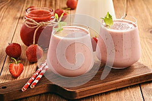 Healthy beverage- strawberry milkshake in glasses on wooden background.