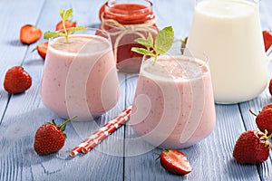 Healthy beverage- strawberry milkshake in glasses on wooden background.