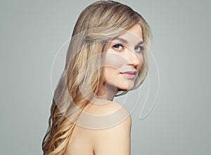 Healthy blonde woman portrait. Girl with long curly hair and clear skin, skincare and wellness concept
