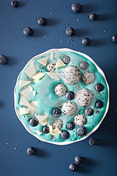 healthy blue spirulina smoothie bowl with blueberry, white chocolate, dragon fruit, chia seed