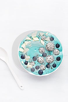 healthy blue spirulina smoothie bowl with blueberry, white chocolate, dragon fruit, chia seed