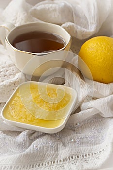 Healthy bowl of pure honey with honey dipper and lemon fruit and puree on vintage white background