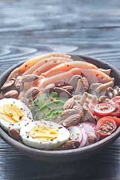 Healthy bowl with salmon, avocado, egg and vegs