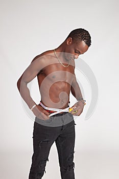 Healthy boy controlling his weight and measuring his waist photo