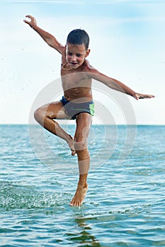 Healthy boy jumping in water