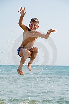 Healthy boy jumping in water