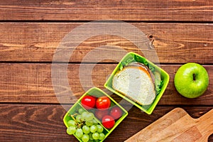 Healthy break with apple, grape and sandwich in lunchbox on home table flat lay mock-up