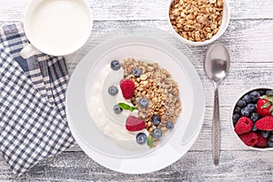 Healthy breakfast with baked granola and greek yogurt. Assorted fresh berries