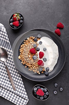 Healthy breakfast with baked granola and greek yogurt. Assorted fresh berries. Vertical photo