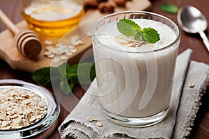 Healthy breakfast of banana smoothie or milkshake with oats and honey decorated mint leaves