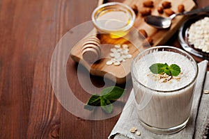 Healthy breakfast of banana smoothie or milkshake with oats and honey decorated mint leaves
