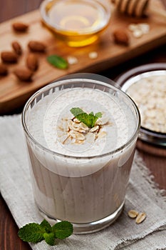 Healthy breakfast of banana smoothie or milkshake with oats and honey decorated mint leaves