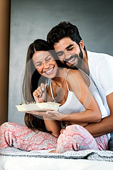 Healthy breakfast in bed. Young beautiful couple in love spending time together. Good morning.