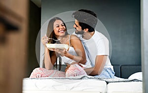 Healthy breakfast in bed. Young beautiful couple in love spending time together. Good morning.