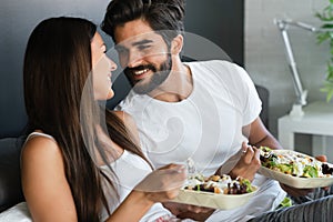 Healthy breakfast in bed. Young beautiful couple in love spending time together. Good morning.