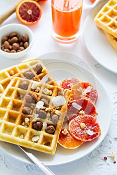 Healthy breakfast. Belgian waffles with nuts and Sicilian oranges