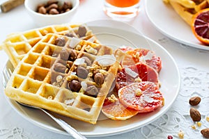 Healthy breakfast. Belgian waffles with nuts and sicilian oranges