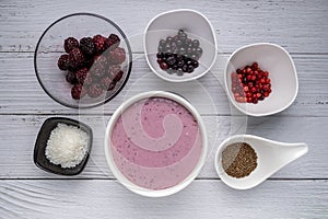 Healthy breakfast berry smoothie bowl with Blueberries, blackberries, chia seeds, raspberry and grounded coconut flakes. top view.