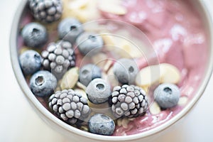 Healthy breakfast berry smoothie bowl topped with banana, granola, Blueberries and chia seeds with copy space