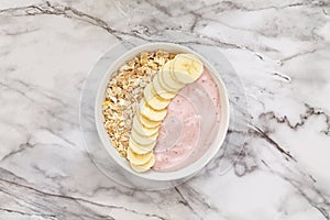 Healthy breakfast berry smoothie bowl topped with banana, muesli and chia seeds. Top view.