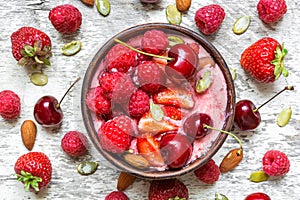 Healthy breakfast berry smoothie bowl topped with raspberry, strawberry, cherry, chia and pumpkin seeds