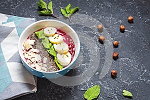 Healthy breakfast bowl - blueberry smoothie with banana, raspberry, almonds and chia seeds