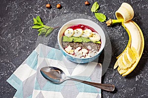 Healthy breakfast bowl - blueberry smoothie with banana, raspberry, almonds and chia seeds