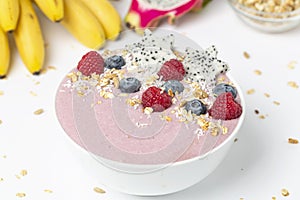 Healthy breakfast bowl: blueberry smoothie with raspberries, bananas, pitaya and granola.