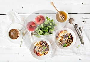 Healthy breakfast. Bowl of oat granola with yogurt, fresh fruit, mint and honey