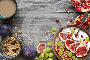 Healthy breakfast. bowl of oat granola with yogurt, pomegranate seeds, figs, grape and nuts with a spoon and cappuccino